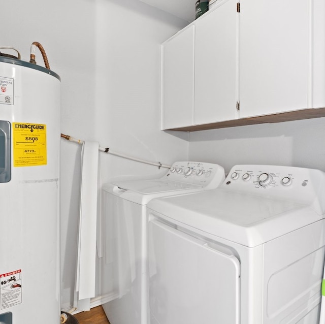 laundry area with electric water heater, cabinets, and washing machine and clothes dryer