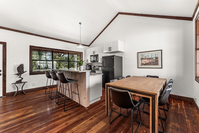 dining area with dark hardwood / wood-style floors and high vaulted ceiling