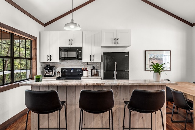 kitchen with a center island with sink, white cabinetry, black appliances, a kitchen breakfast bar, and dark hardwood / wood-style floors