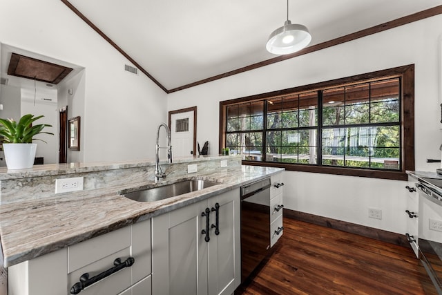 kitchen with sink, light stone counters, lofted ceiling, stainless steel dishwasher, and white cabinetry