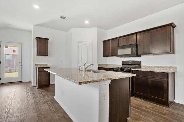 kitchen with an island with sink, black appliances, dark wood-type flooring, and sink