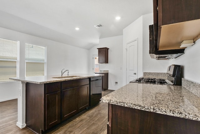 kitchen with hardwood / wood-style flooring, a kitchen island with sink, sink, and range