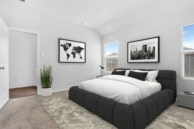 carpeted bedroom featuring lofted ceiling and multiple windows