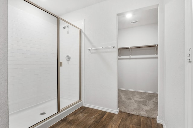 bathroom with wood-type flooring and an enclosed shower