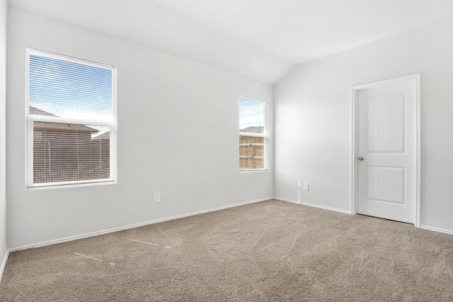 empty room with vaulted ceiling and light carpet