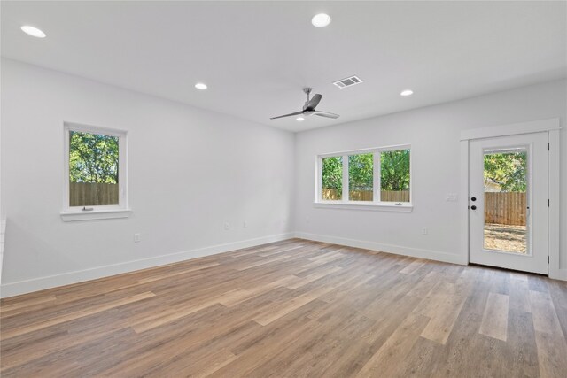 spare room with ceiling fan, a wealth of natural light, and light hardwood / wood-style flooring