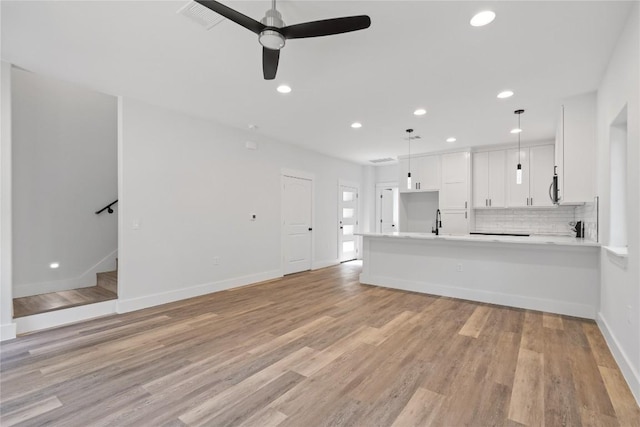 909 Vargas Rd Unit B, Austin, TX 78741 - unfurnished living room featuring light wood-style flooring, baseboards, recessed lighting, stairway, and ceiling fan