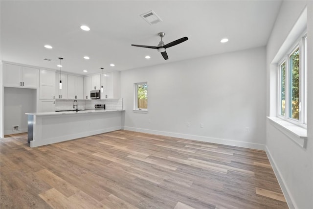 909 Vargas Rd Unit B, Austin, TX 78741 - unfurnished living room featuring baseboards, light wood finished floors, visible vents, and recessed lighting