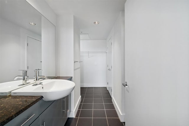 bathroom with tile patterned floors, baseboards, vanity, a spacious closet, and recessed lighting