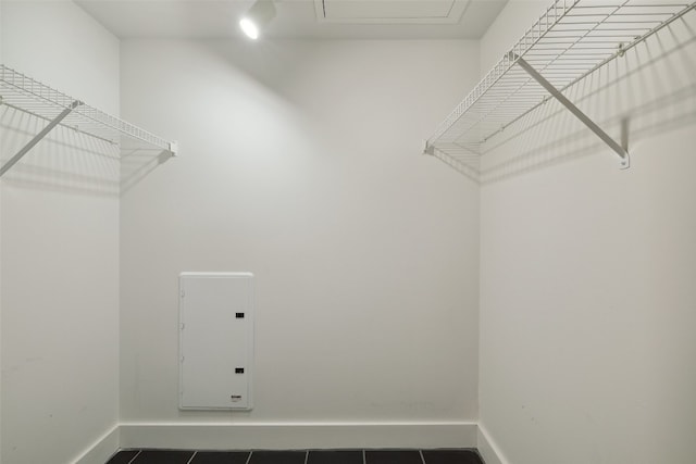 spacious closet featuring dark tile patterned floors and electric panel