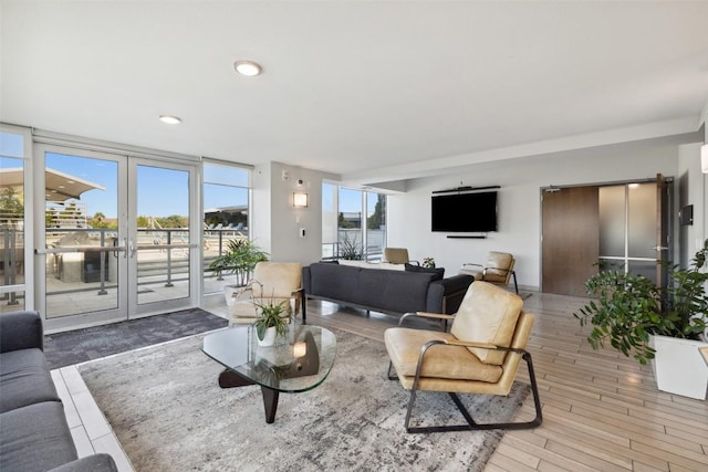 living room with french doors, recessed lighting, expansive windows, and wood finished floors