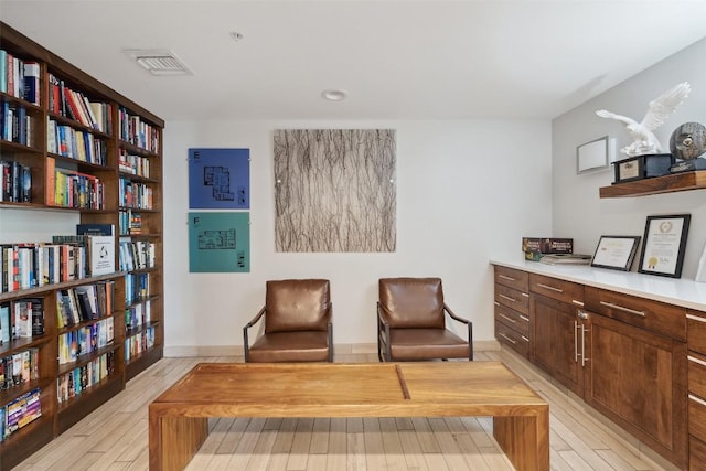 living area with light wood-type flooring and visible vents