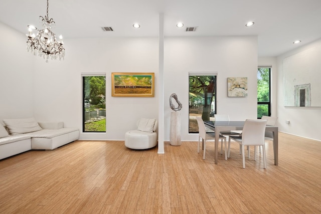 dining space featuring light hardwood / wood-style floors and a notable chandelier