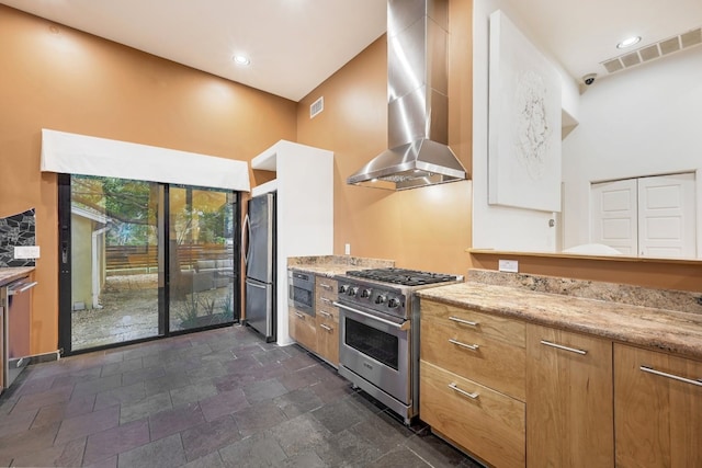 kitchen featuring light stone countertops, wall chimney range hood, and appliances with stainless steel finishes