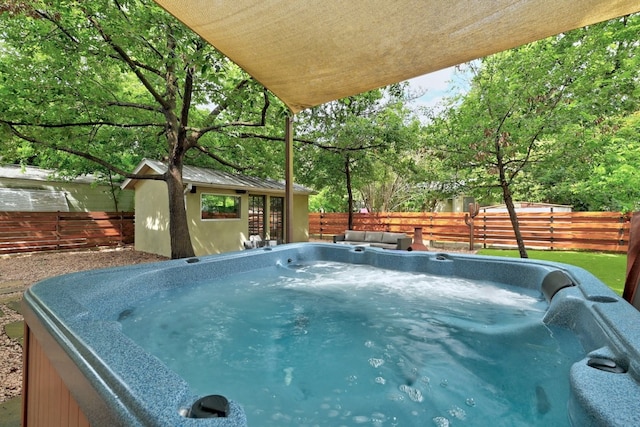 view of swimming pool with a hot tub