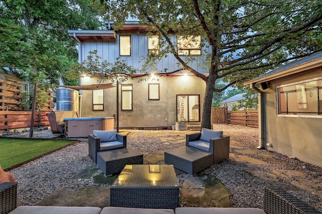 rear view of property featuring a hot tub and a patio area