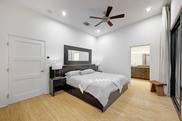 bedroom featuring ceiling fan, light wood-type flooring, and ensuite bathroom