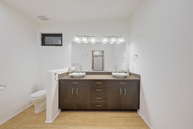 bathroom with vanity, toilet, and hardwood / wood-style flooring