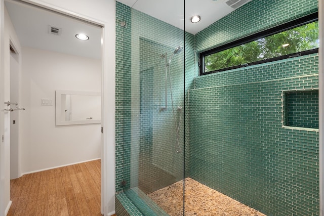 bathroom featuring a tile shower and hardwood / wood-style flooring