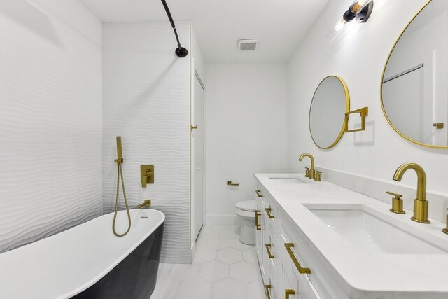 bathroom featuring vanity, toilet, tile patterned flooring, and a bathing tub