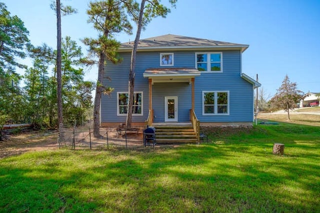 rear view of house featuring a lawn