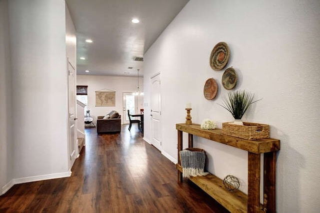 corridor featuring a notable chandelier and dark hardwood / wood-style floors