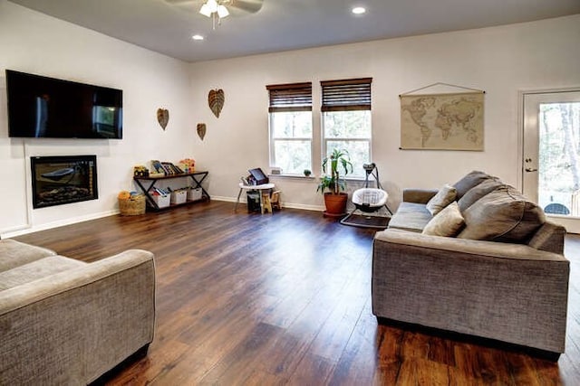 living room with ceiling fan and dark wood-type flooring