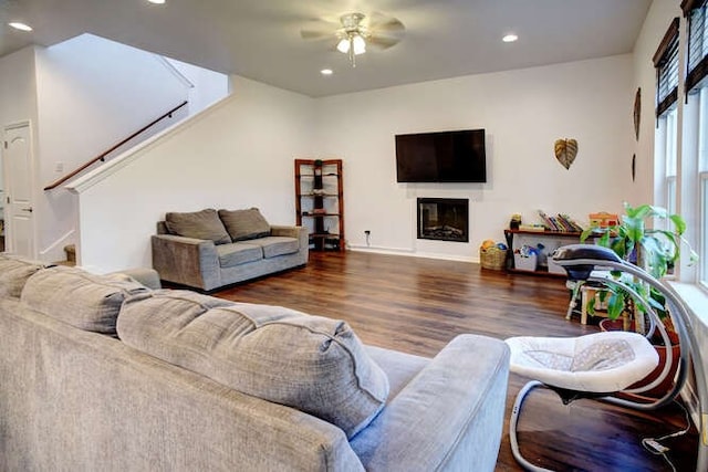 living room featuring ceiling fan and dark hardwood / wood-style floors