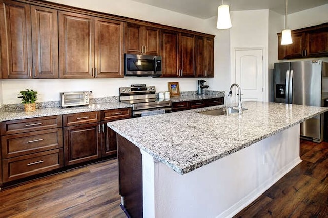 kitchen featuring an island with sink, appliances with stainless steel finishes, and dark hardwood / wood-style floors