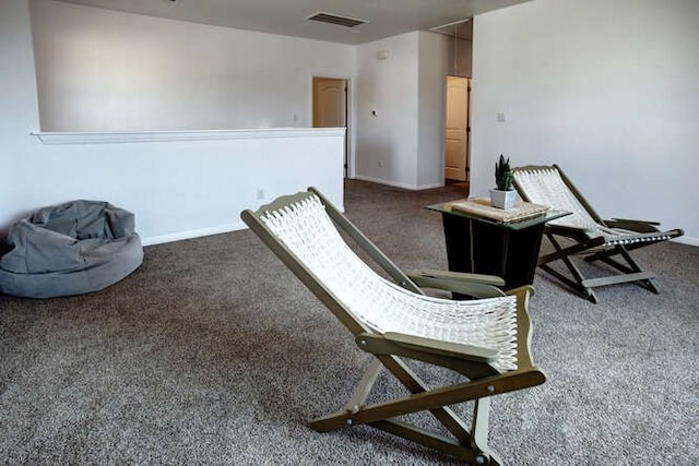 sitting room featuring dark colored carpet