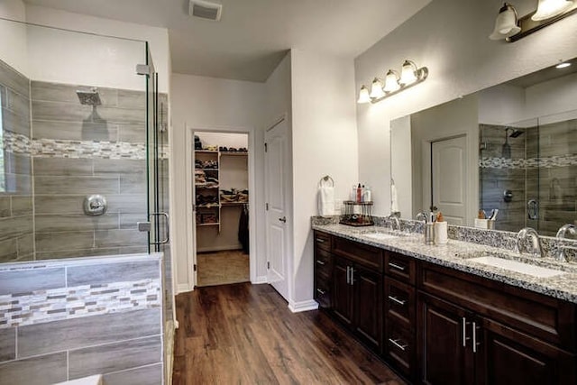 bathroom featuring a shower with door, hardwood / wood-style flooring, and vanity