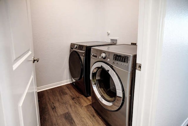 clothes washing area with separate washer and dryer and dark hardwood / wood-style flooring