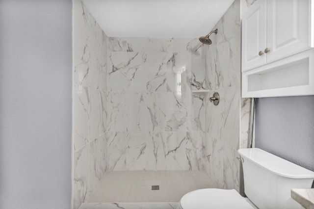 bathroom with toilet and tiled shower