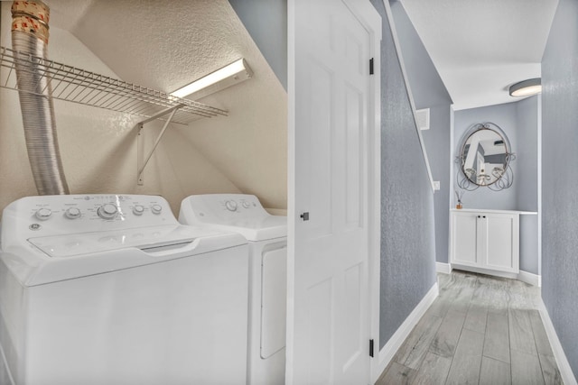 laundry area with light hardwood / wood-style floors and washing machine and clothes dryer