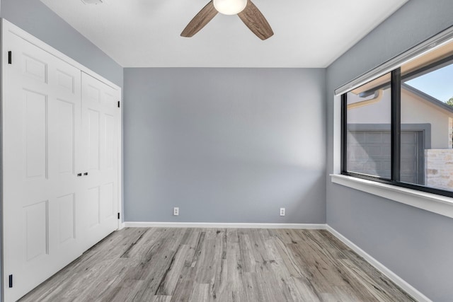 unfurnished bedroom with light wood-type flooring, a closet, and ceiling fan