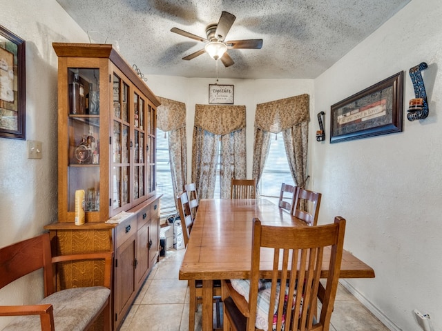 tiled dining space featuring ceiling fan and a textured ceiling