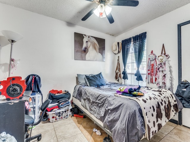 tiled bedroom with a textured ceiling and ceiling fan