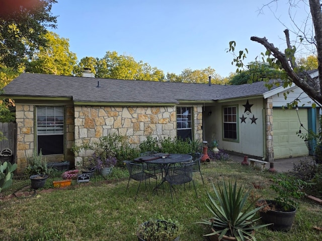 back of house featuring a garage and a lawn