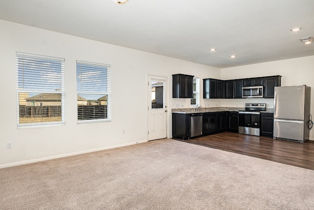 kitchen featuring dark carpet, appliances with stainless steel finishes, and sink