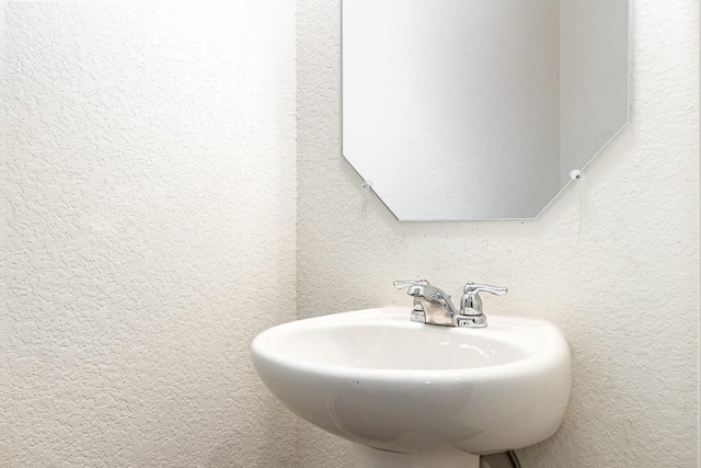 bathroom with a textured wall and a sink