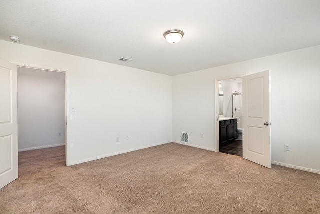 carpeted empty room featuring visible vents and baseboards