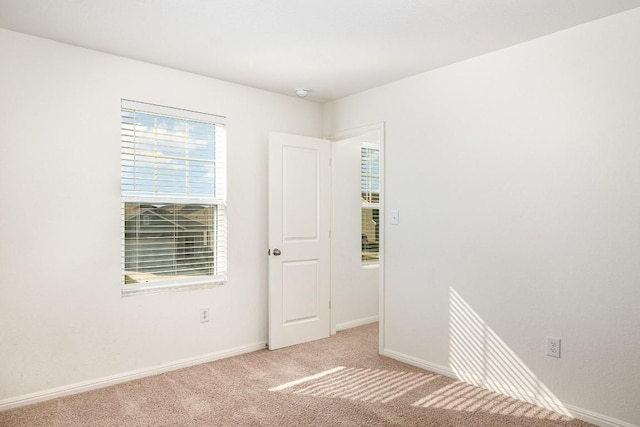 carpeted empty room with baseboards