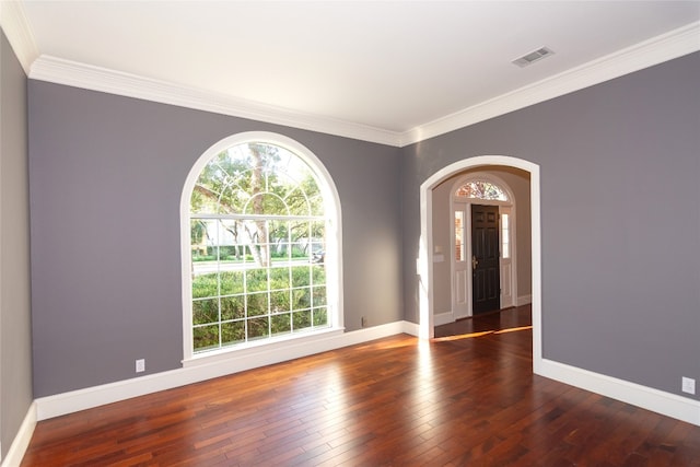 empty room featuring crown molding and dark hardwood / wood-style flooring