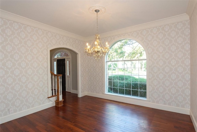unfurnished dining area featuring wallpapered walls, an inviting chandelier, dark wood-type flooring, arched walkways, and baseboards