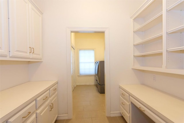 laundry room featuring baseboards, laundry area, light tile patterned floors, and washer / dryer