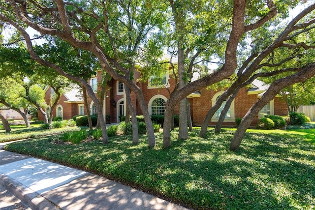 view of front of house with a front lawn and brick siding