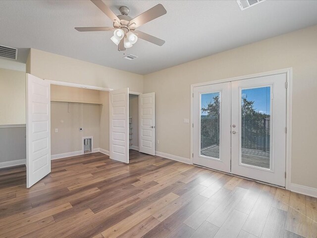 unfurnished bedroom with french doors, visible vents, access to exterior, wood finished floors, and baseboards