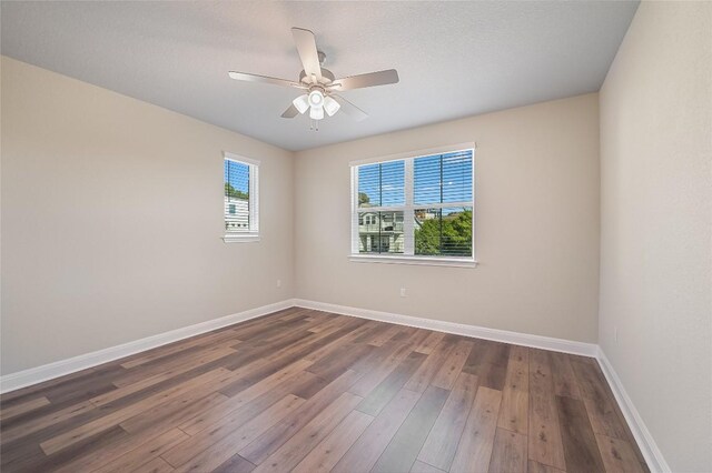 spare room with wood-type flooring, baseboards, and ceiling fan