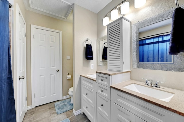 bathroom with toilet, vanity, and baseboards