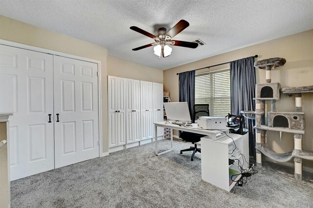 office area featuring visible vents, a textured ceiling, ceiling fan, and carpet floors